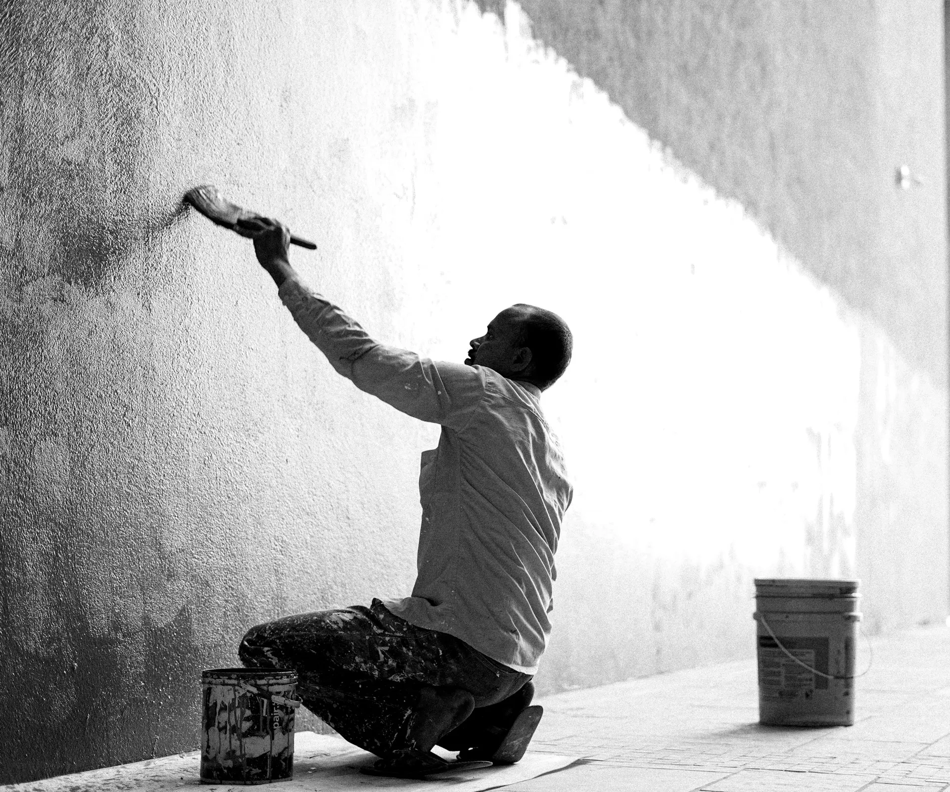 Maler beim Streichen einer Wand mit Farbroller